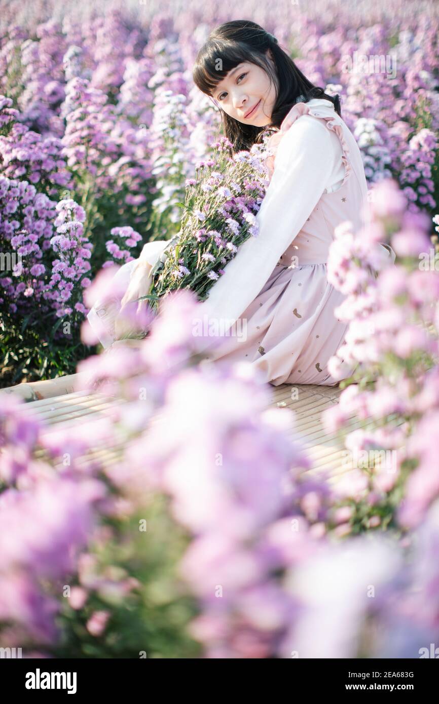 Portrait de fille asiatique avec fond de fleurs violettes Banque D'Images