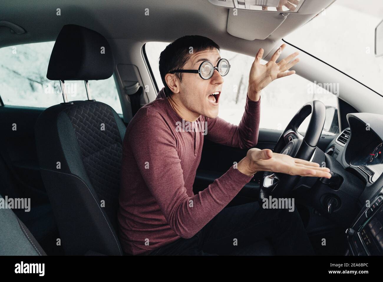 homme à courte vue avec de grandes lunettes 5 diopters est surpris et ennuyé qu'il y a eu un accident avec une autre voiture. Fait des gestes et exprime fortement Banque D'Images