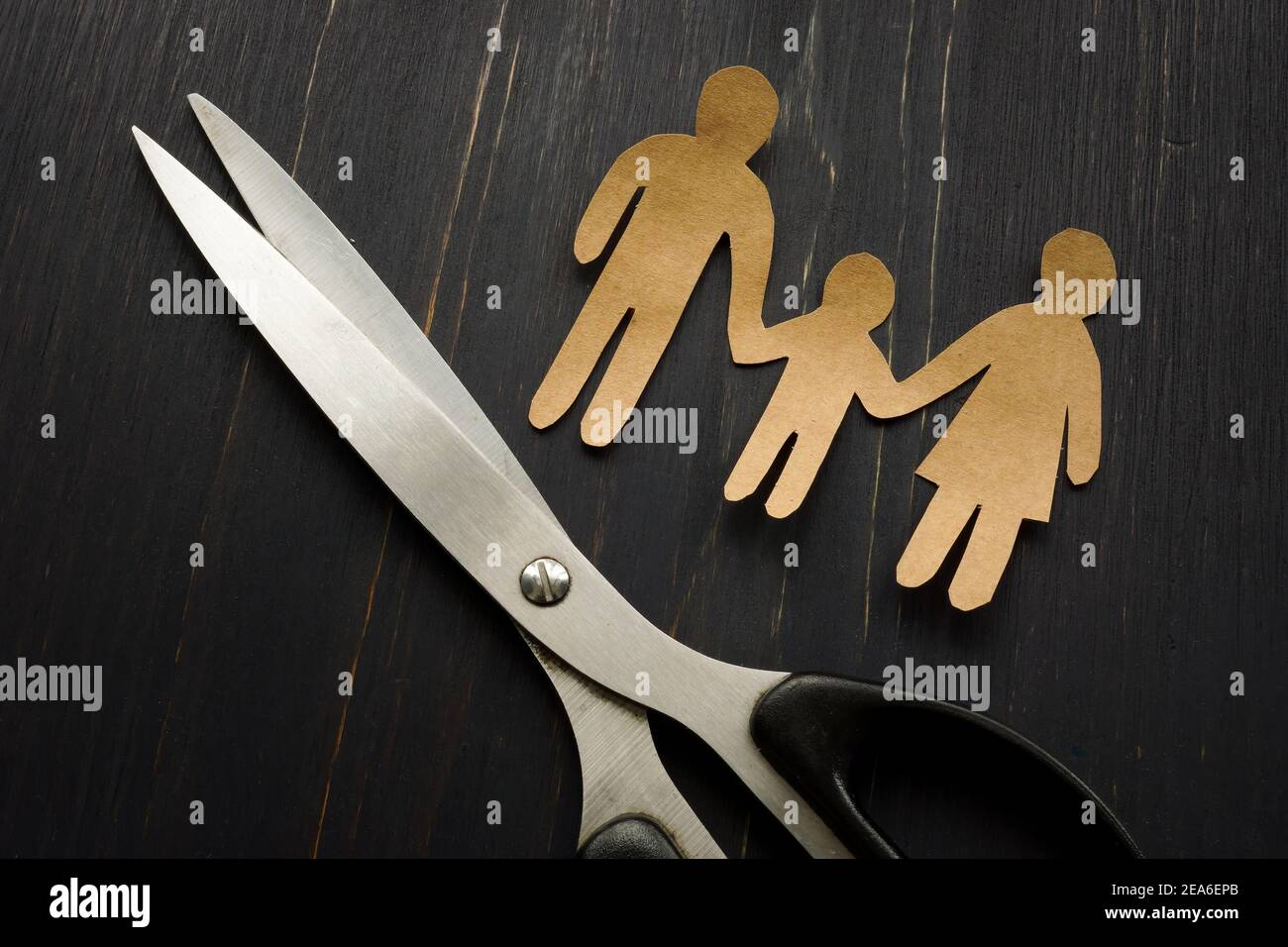 Concept d'aliénation parentale. Les chiffres de la famille et les ciseaux comme symbole du divorce. Banque D'Images