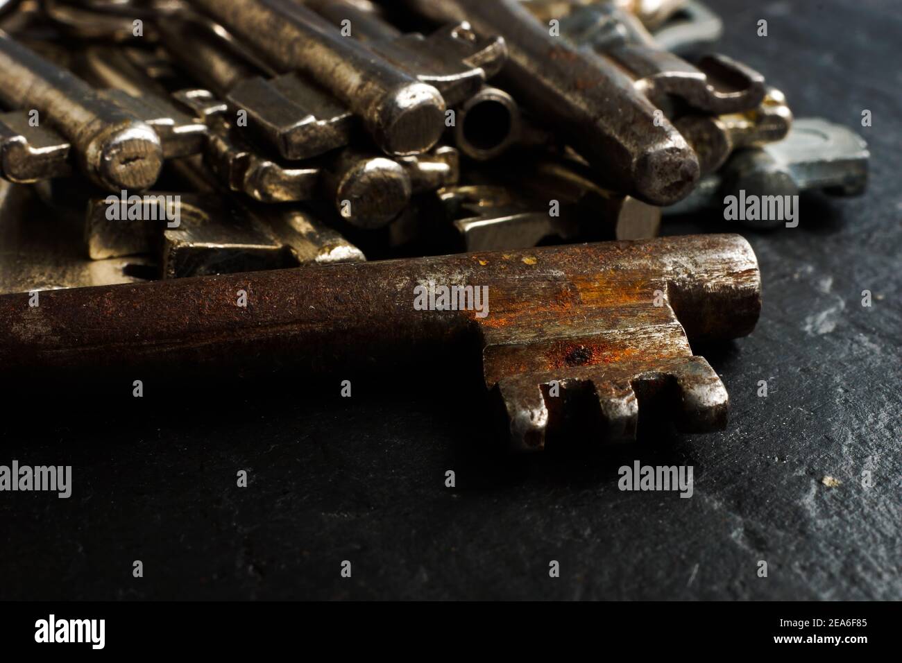 Gros plan de la vieille clé en métal rouillé et de l'arrière-plan des clés. Banque D'Images