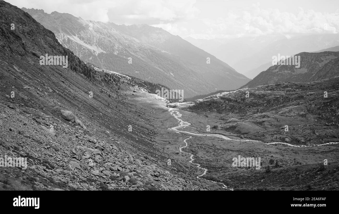 Petite rivière entourée de montagnes dans une vallée alpine des Alpes italiennes (Trentin, Italie, Europe) Banque D'Images