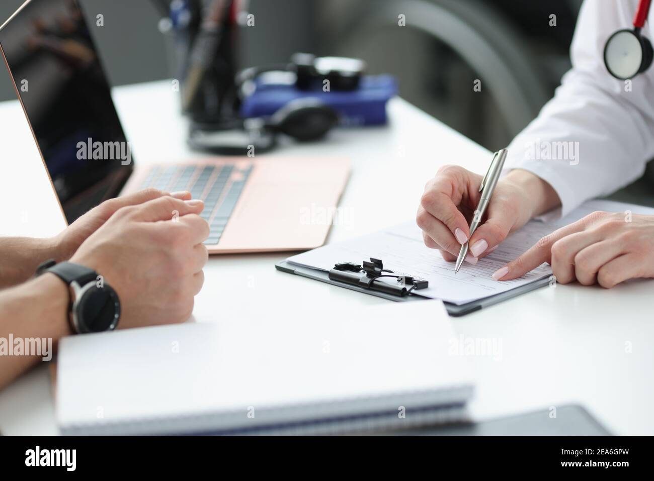 Les médecins écrivent les plaintes des patients en gros plan sur les antécédents médicaux Banque D'Images