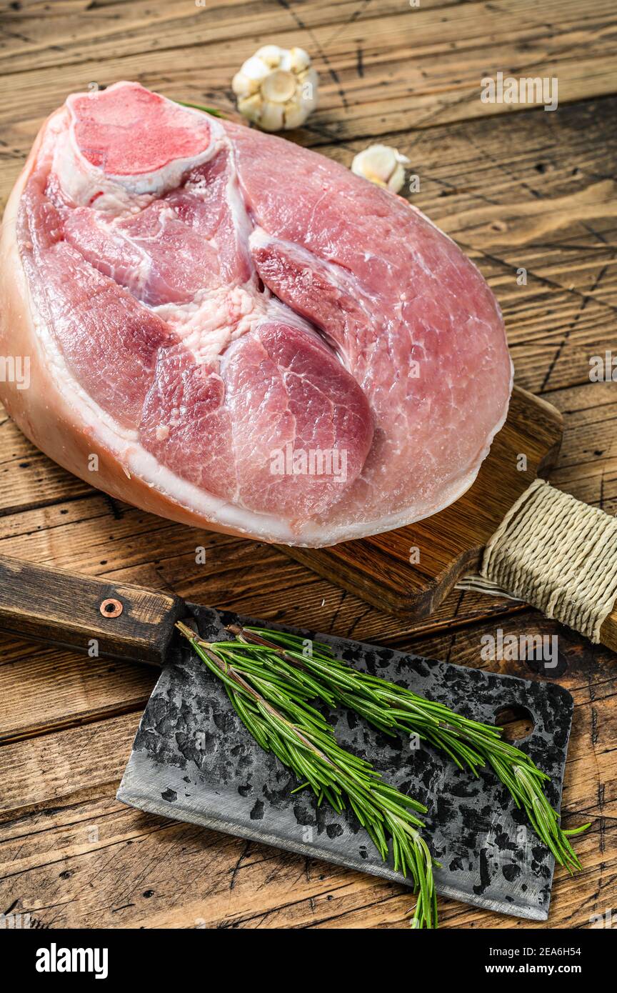 Jambon de porc cru coupé. Viande de jambe. Arrière-plan en bois. Vue de dessus Banque D'Images