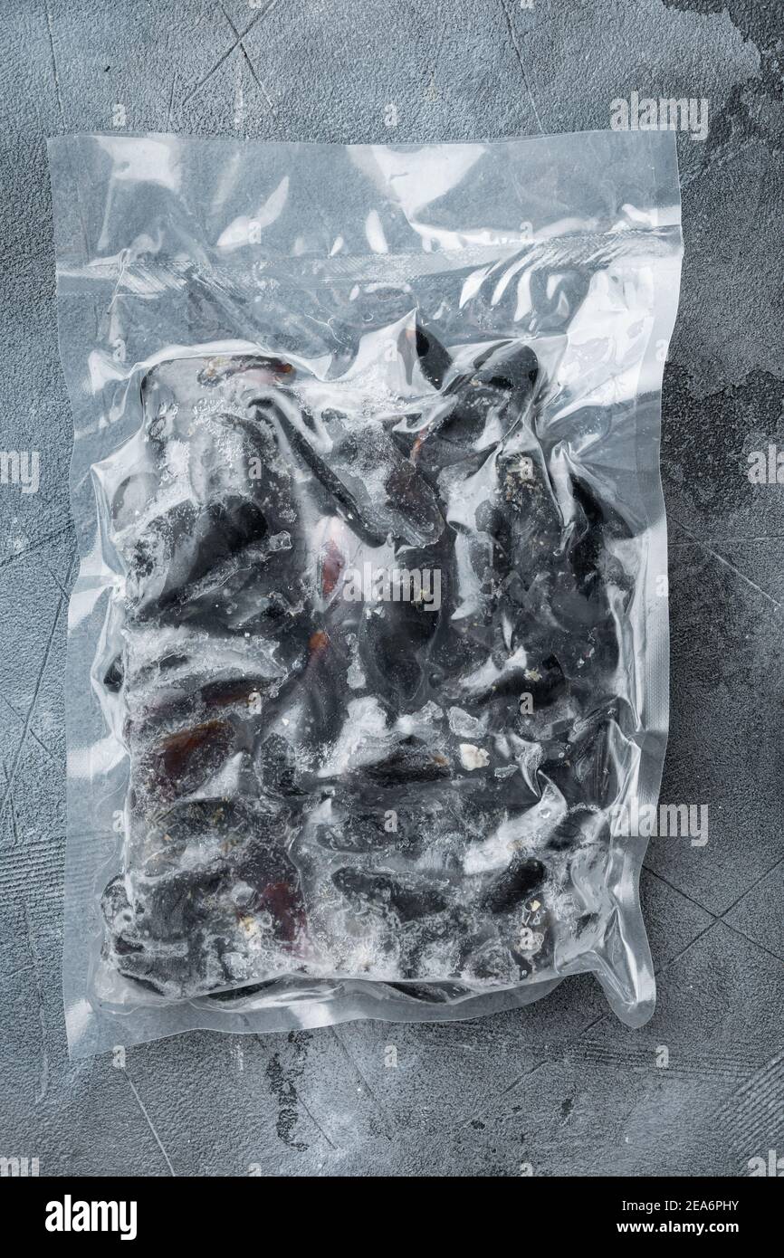 Moules surgelées emballées sous vide, sur fond gris, plan plat avec vue de dessus Banque D'Images