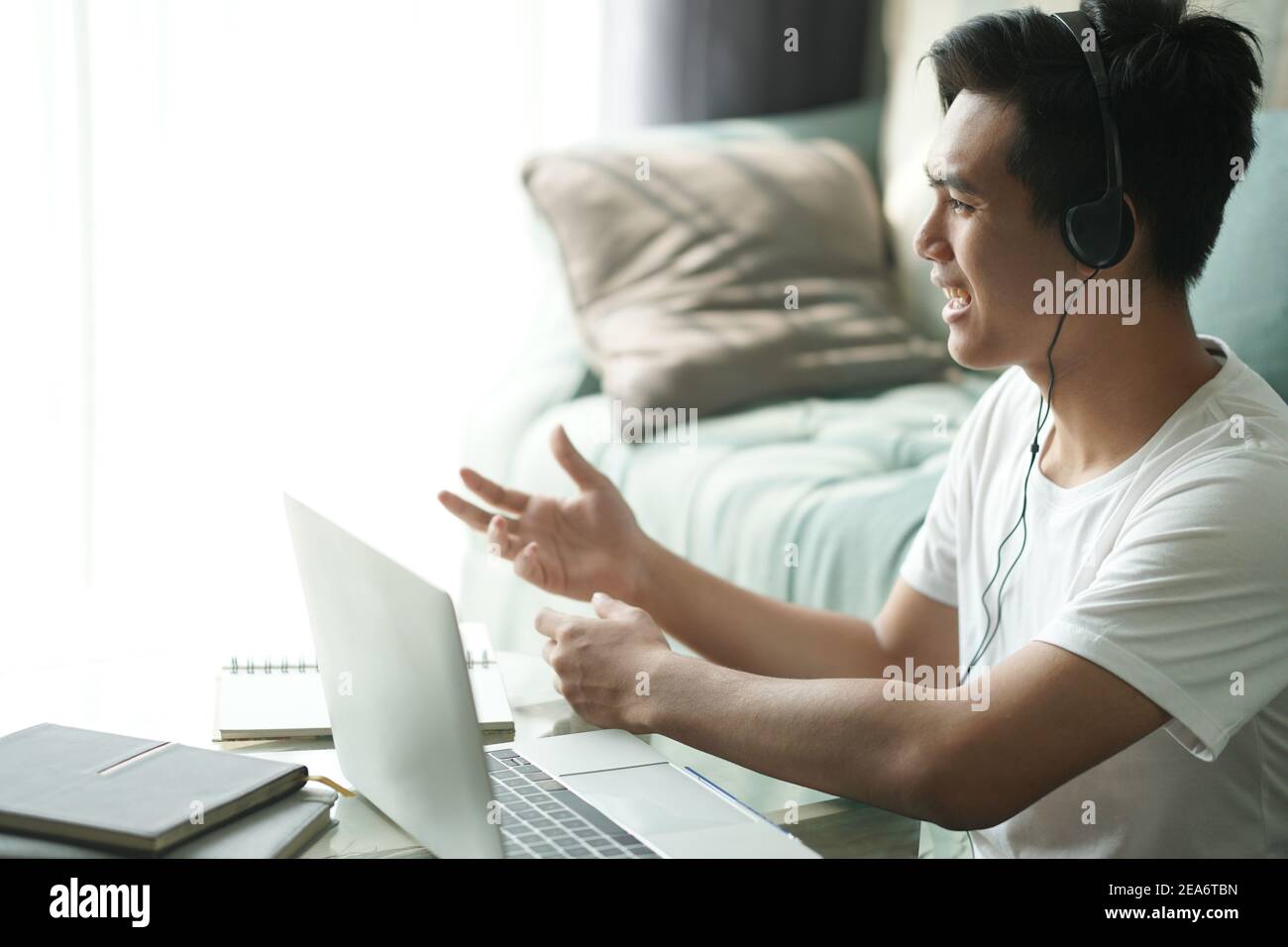 asiatique jeune adolescent étudiant homme entrepreneur porter des écouteurs travaillant par vidéoconférence étudiant l'apprentissage en ligne à la maison. e-learning webinar mee Banque D'Images