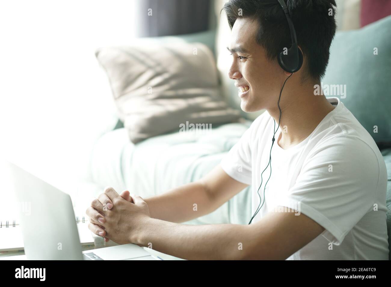 asiatique jeune adolescent étudiant homme entrepreneur porter des écouteurs travaillant par vidéoconférence étudiant l'apprentissage en ligne à la maison. e-learning webinar mee Banque D'Images