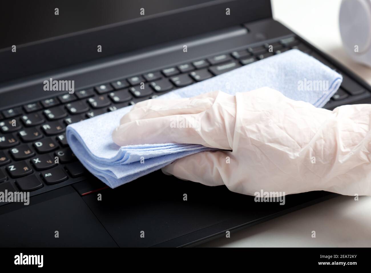 Femmes mains en gants désinfection du clavier d'ordinateur portable à l'aide de lingettes désinfectantes humides. Femme nettoyant le clavier contre les virus les bactéries empêchent le covid Banque D'Images