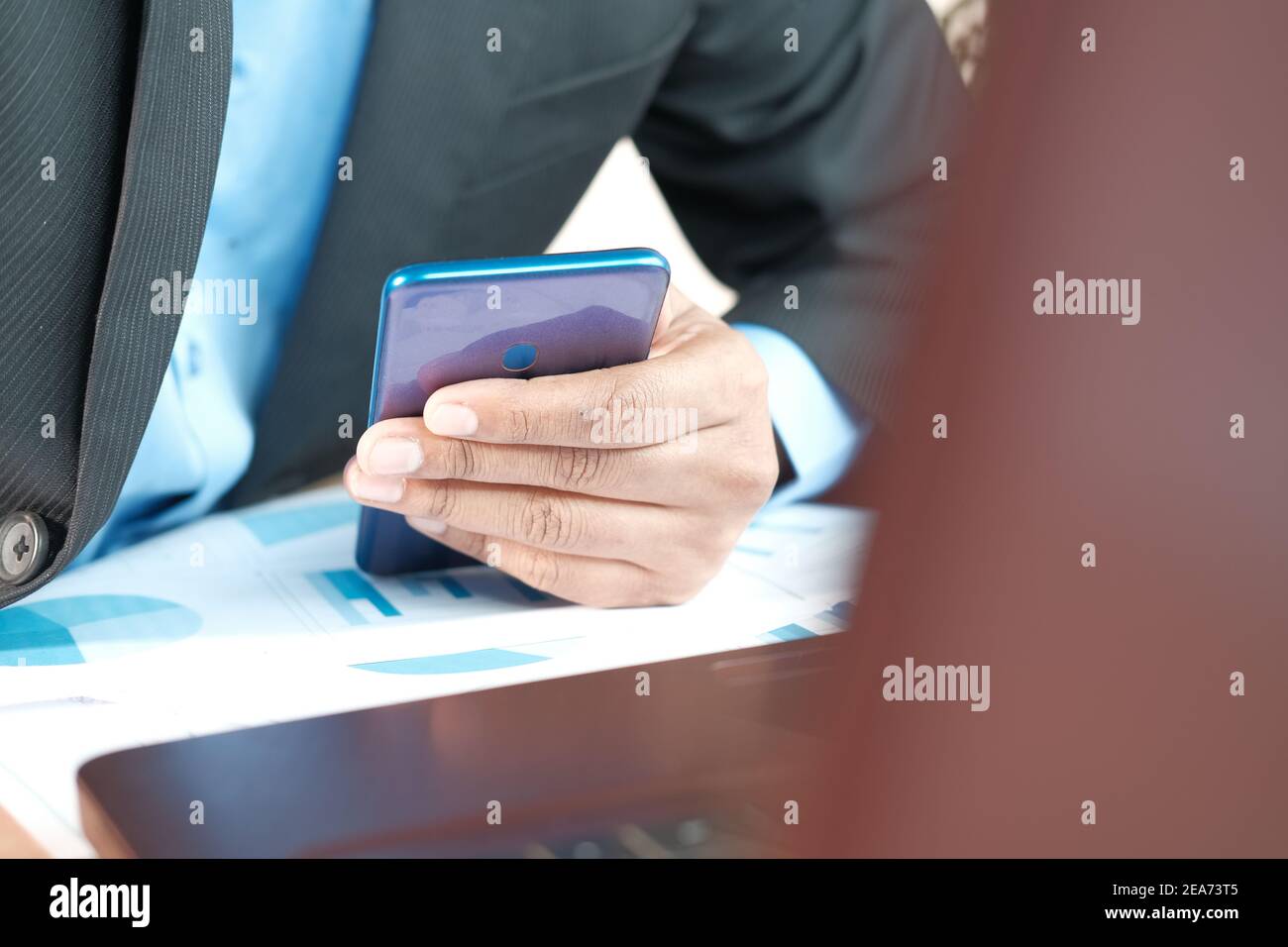 jeune homme travaillant sur un bureau et utilisant un smartphone Banque D'Images