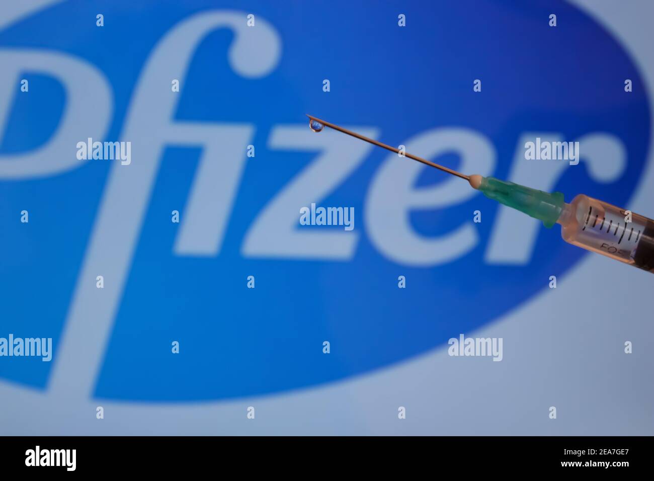 Concept du vaccin Covid-19. Aiguille de seringue, logo Pfizer sur l'arrière-plan. Concept de vaccination contre le coronavirus. Banque D'Images