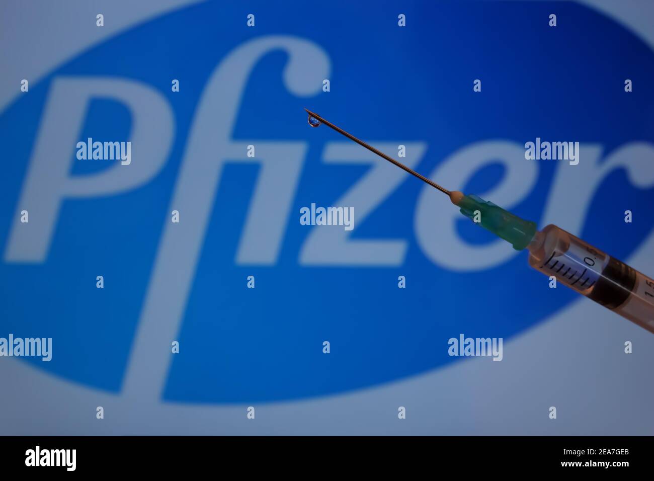 Concept du vaccin Covid-19. Aiguille de seringue, logo Pfizer sur l'arrière-plan. Concept de vaccination contre le coronavirus. Banque D'Images