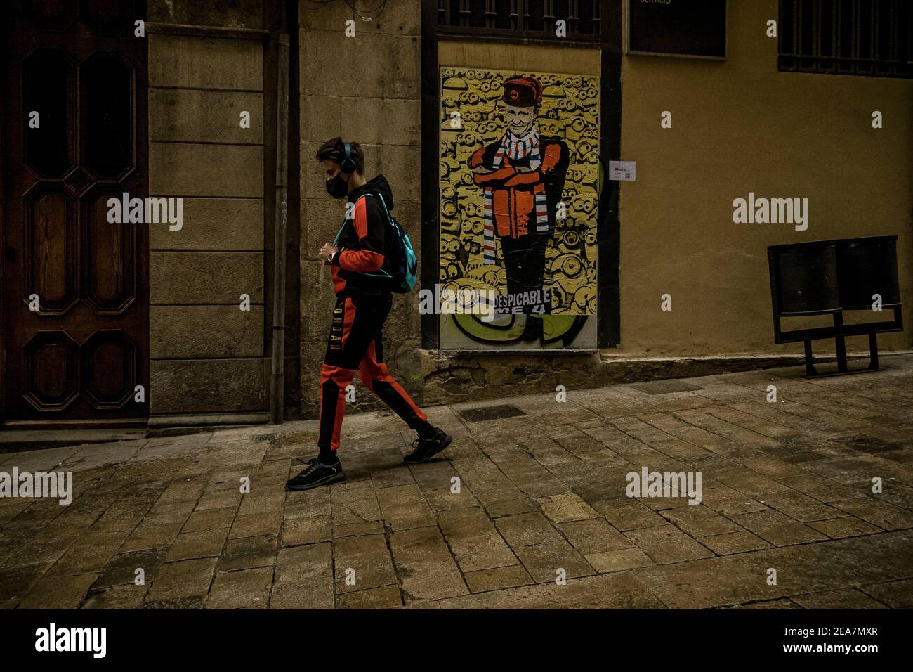 Barcelone, Espagne. 8 février 2021. Un groupe de banlieue passe devant un nouveau graffiti de l'artiste urbain italien TVBoy, Salvatore Benintende, intitulé « Despicable Me 4 » et nommé d'après une célèbre franchise de cinéma, présente le président russe Vladimir Poutine devant les minions Credit: Matthias Oesterle/Alay Live News Banque D'Images