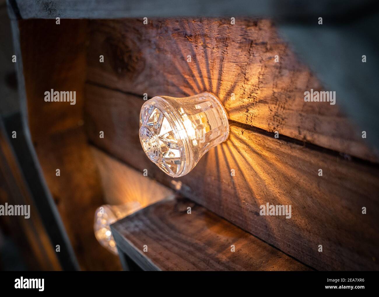 Gros plan sur une ampoule électrique lumineuse sur une grande taille rustique lettres d'amour de mariage en bois Banque D'Images