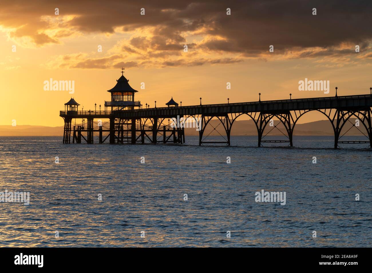 Clevedon Pier magnifiquement rétroéclairé avec un coucher de soleil doré Banque D'Images