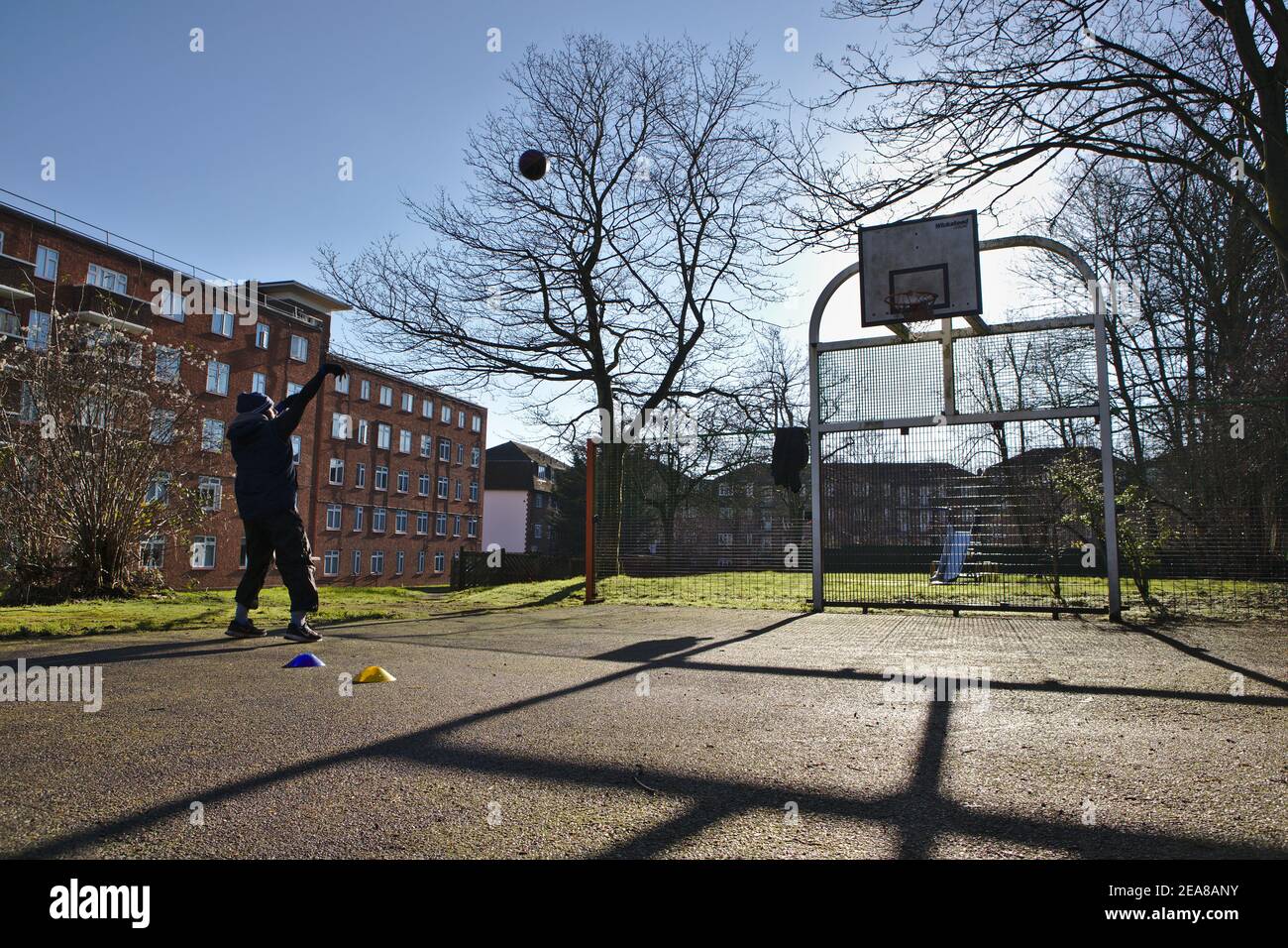 Jeune homme jouant seul au basket-ball Banque D'Images