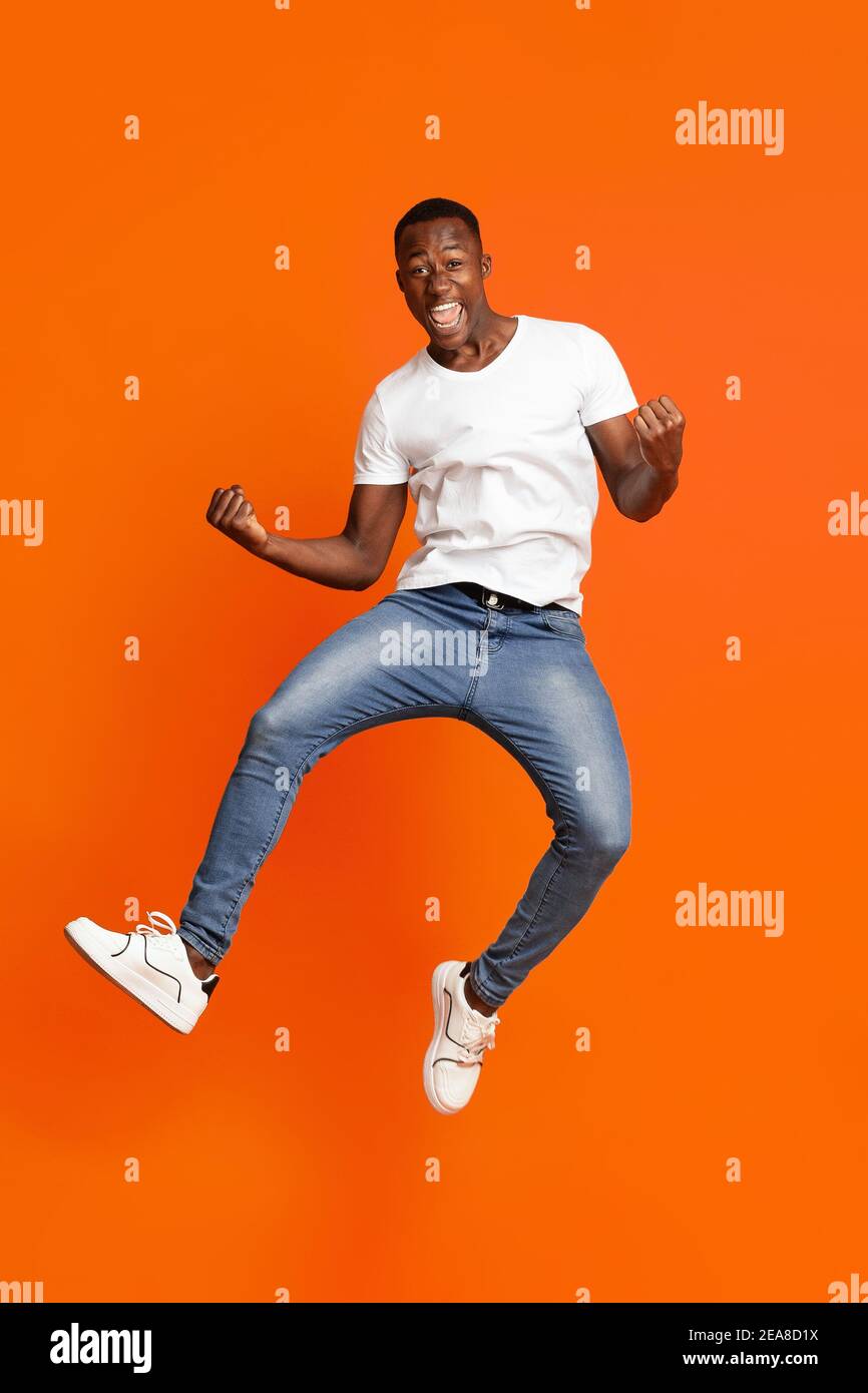 Black Guy gagnant sauter vers le haut et montrant des chiffres drôles Banque D'Images