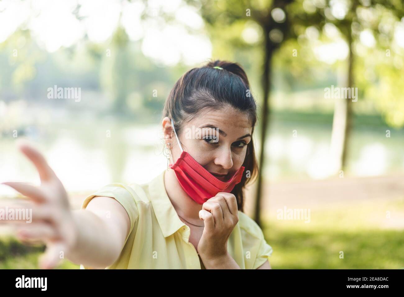 Femme souriante Profitez de la vie au parc en respirant de l'air frais Après l'épidémie de coronavirus - Nouveau concept normal de personnes ayant masque de protection amusant Banque D'Images