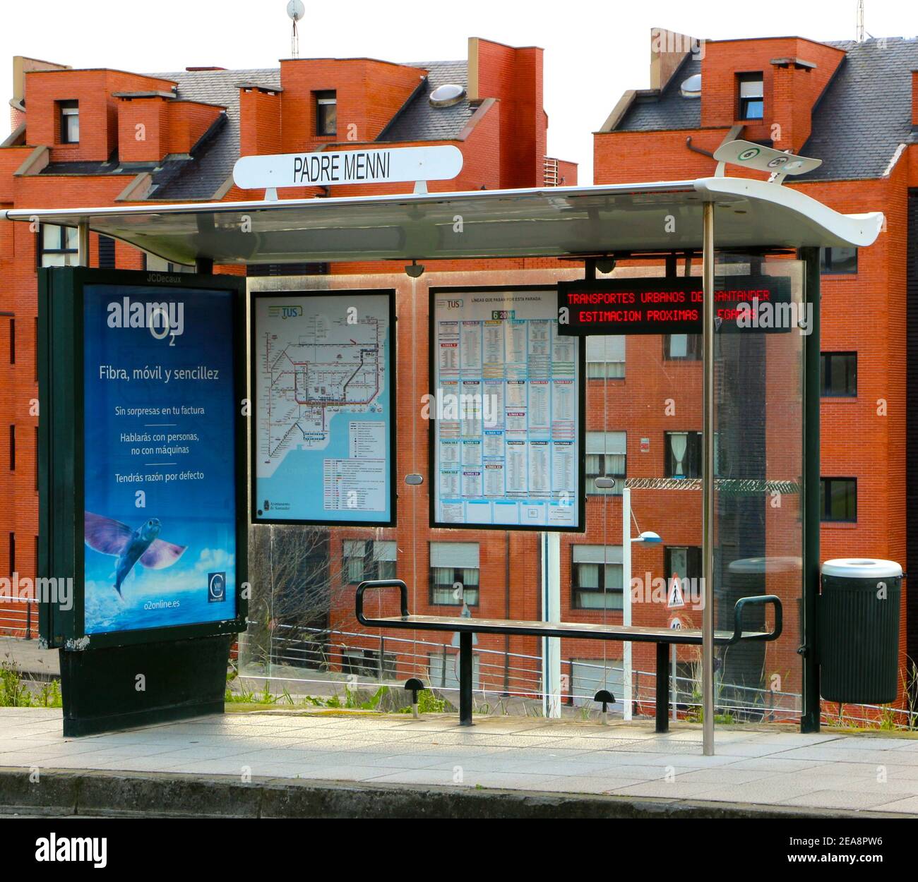 O2 panneau publicitaire sur un arrêt de bus vide à Santander Cantabria Espagne avec des blocs de briques orange appartements derrière Banque D'Images