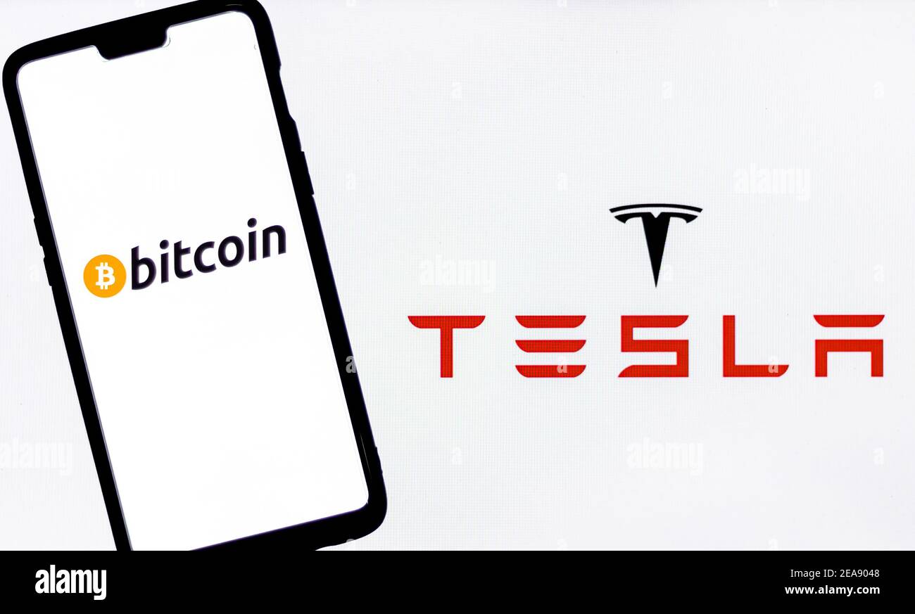 Logo Bitcoin sur un smartphone contre le logo Tesla en arrière-plan. Banque D'Images