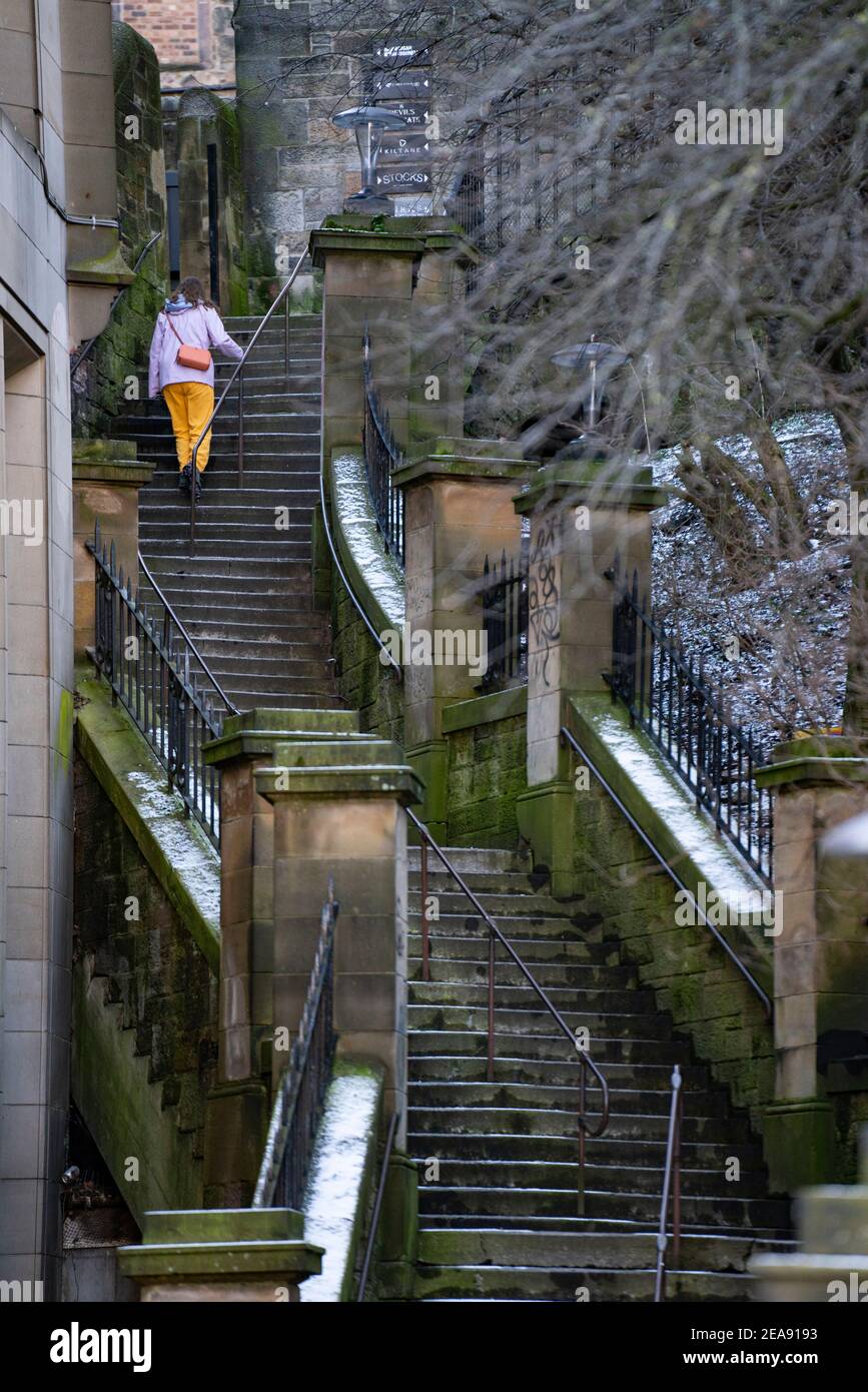 Femme grimpant les étapes de l'actualité dans la vieille ville d'Édimbourg, en Écosse, au Royaume-Uni Banque D'Images