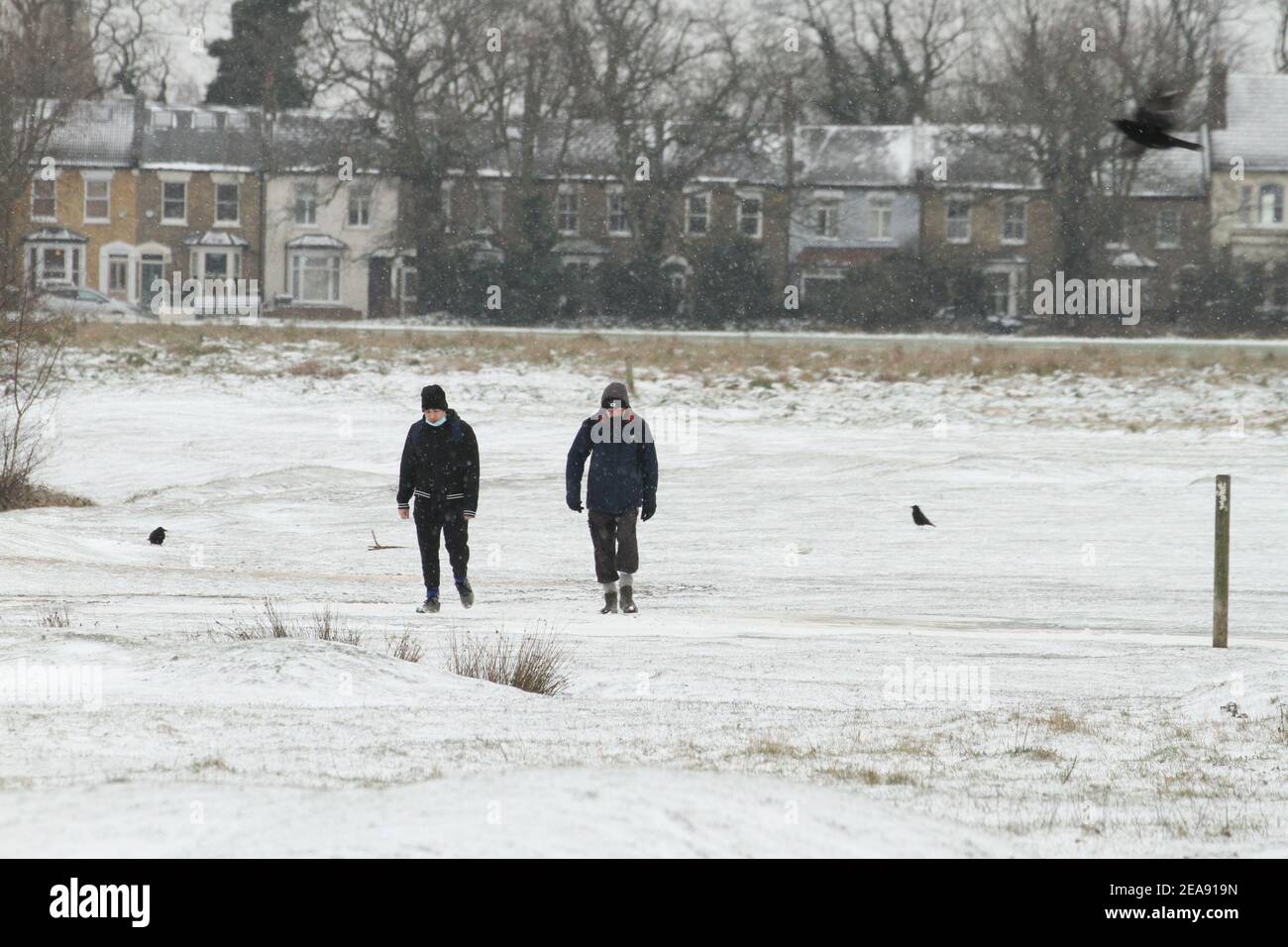 Les gens marchent à travers un parc Wanstead couvert de neige à Redbridge. De fortes chutes de neige et de glace ont perturbé certaines parties du Royaume-Uni, Londres recevant environ 5 cm de neige. Les vents forts de l'est de la tempête Darcy ont plongé les températures dans certaines parties du Royaume-Uni en dessous de moins un. Banque D'Images
