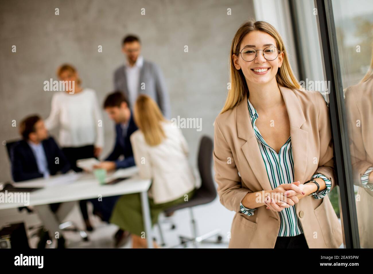 Jolie jeune femme d'affaires debout dans le bureau devant de son équipe Banque D'Images