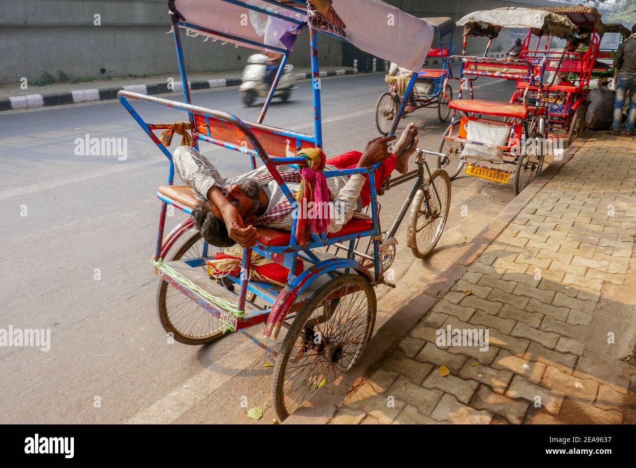 Pousse-pousse avec chauffeur endormi à Delhi, Inde Banque D'Images