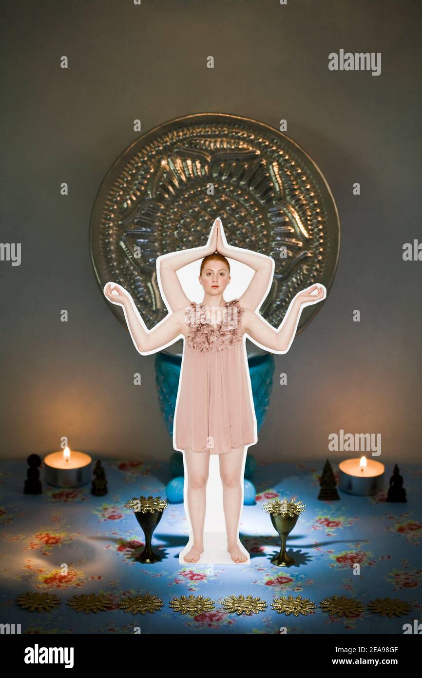 jeune femme en position de main de yoga avec mini robe, debout sur fond bleu avec des chandelles, fond sombre avec disque argenté, collage photo Banque D'Images