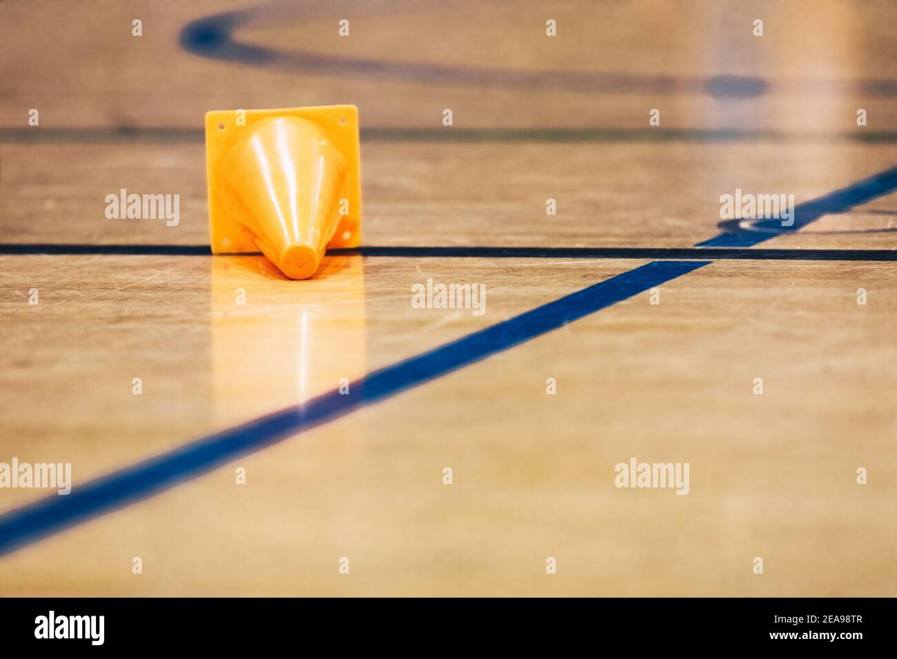 Terrain d'entraînement Orange Sports situé sur une surface brillante d'un plancher de sport en bois. Football en intérieur, terrain d'entraînement de basket-ball Banque D'Images