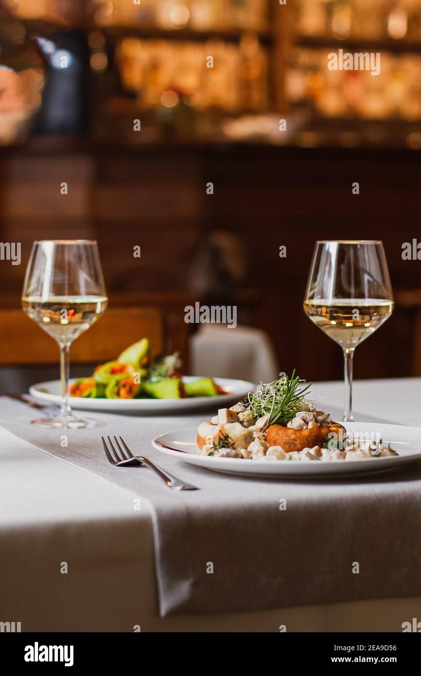 Champignons farcis au fromage, tige de champignons et micro-vert sur la plaque blanche avec un verre de vin au restaurant Banque D'Images