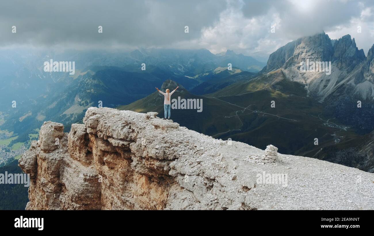 Paysage étonnant de rochers de montagne et femme debout sur le dessus avec les bras étirés. Concept de liberté. Banque D'Images