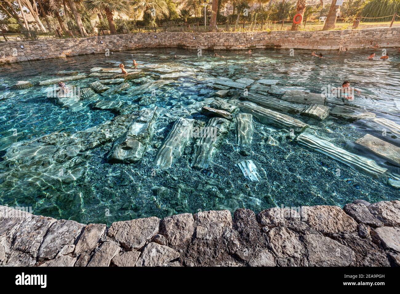 08 septembre 2020, Pamukkale, Turquie: Ancienne piscine avec sources thermales et vestiges de colonnes est un endroit populaire pour les touristes à se détendre après la marche Banque D'Images