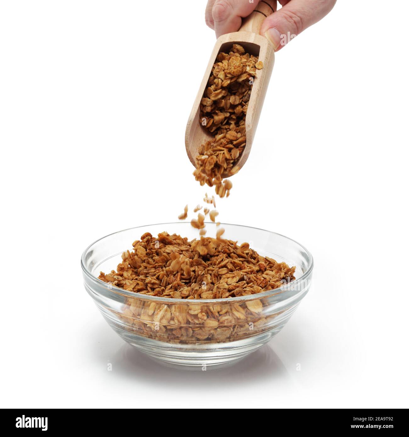 La granola étant vidée d'une pelle dans un bol de petit déjeuner Banque D'Images