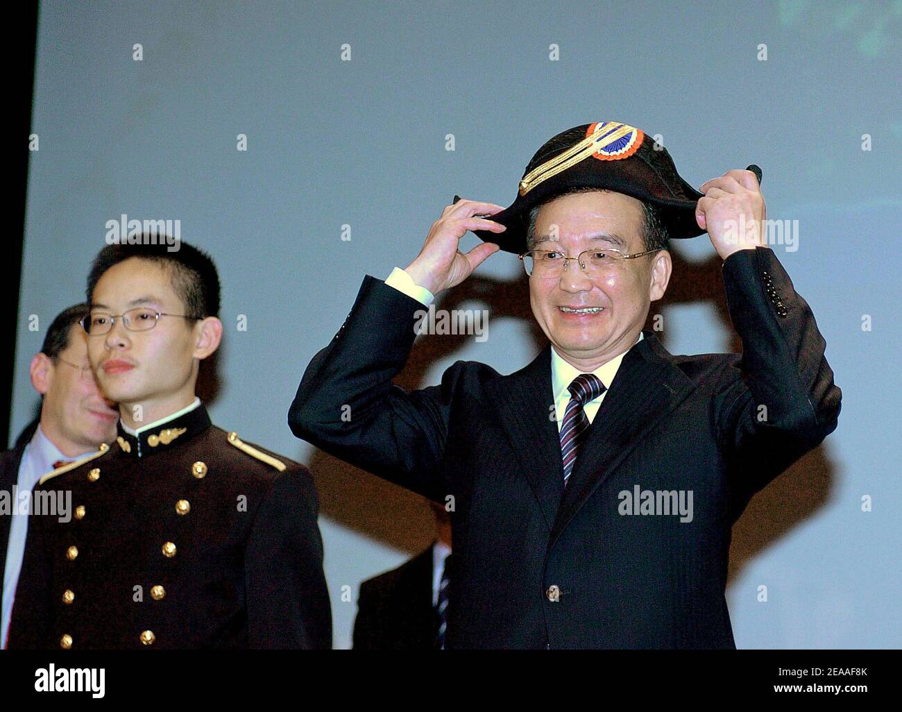 Le Premier ministre chinois Wen Jiabao s'applique alors qu'il porte le  chapeau traditionnel de l'école Polytechnique d'élite de l'ingénieur  militaire français, le 6 décembre 2005, à Palaiseau, au sud de Paris. Wen