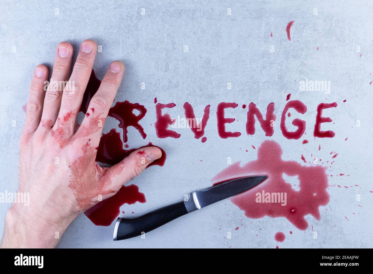 main, un couteau sanglant, taches de sang sur le bras, le mot vengeance est inscrit dans le sang. Banque D'Images