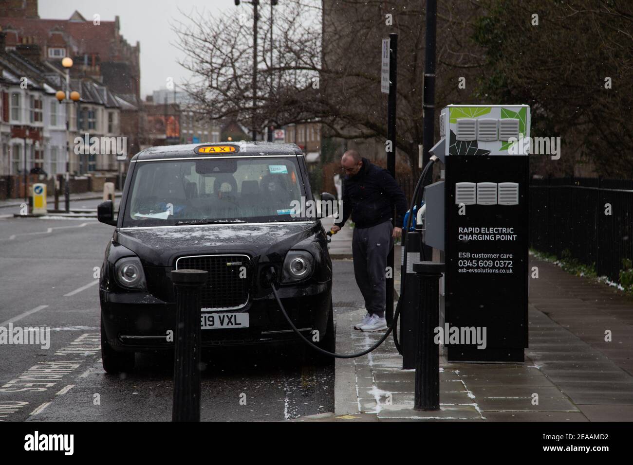 Neige à Londres - UN chauffeur de taxi noir charge son taxi à fulham et déneiger son taxi. 0802/2021 Banque D'Images