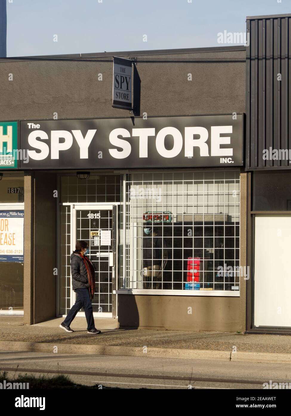 Femme passant devant le magasin Spy à Vancouver, en Colombie-Britannique, au Canada Banque D'Images