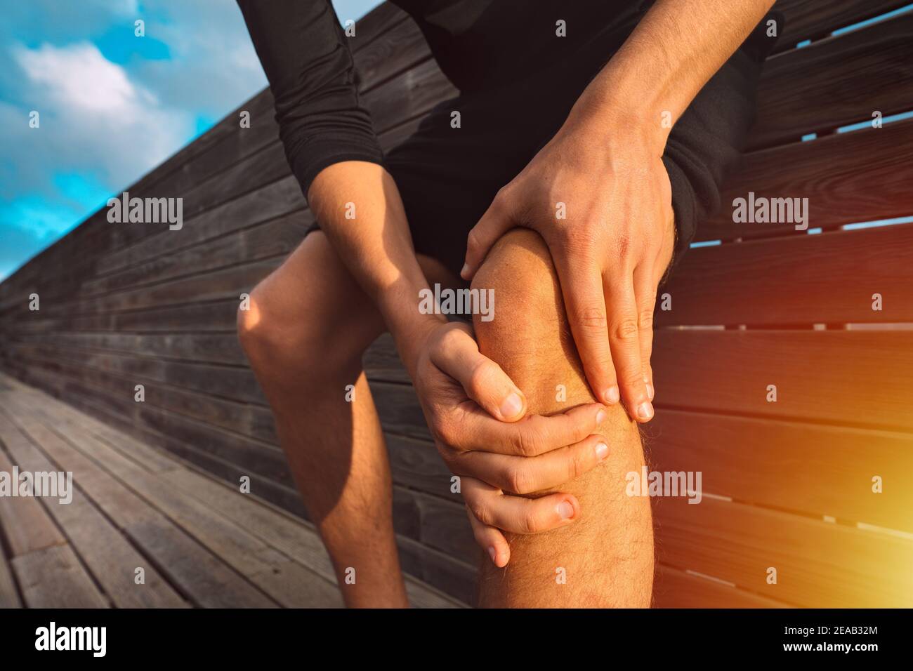 Homme tenant son genou douloureux. Lésion et douleur au genou de l'athlète. Blessure résultant de l'entraînement Banque D'Images