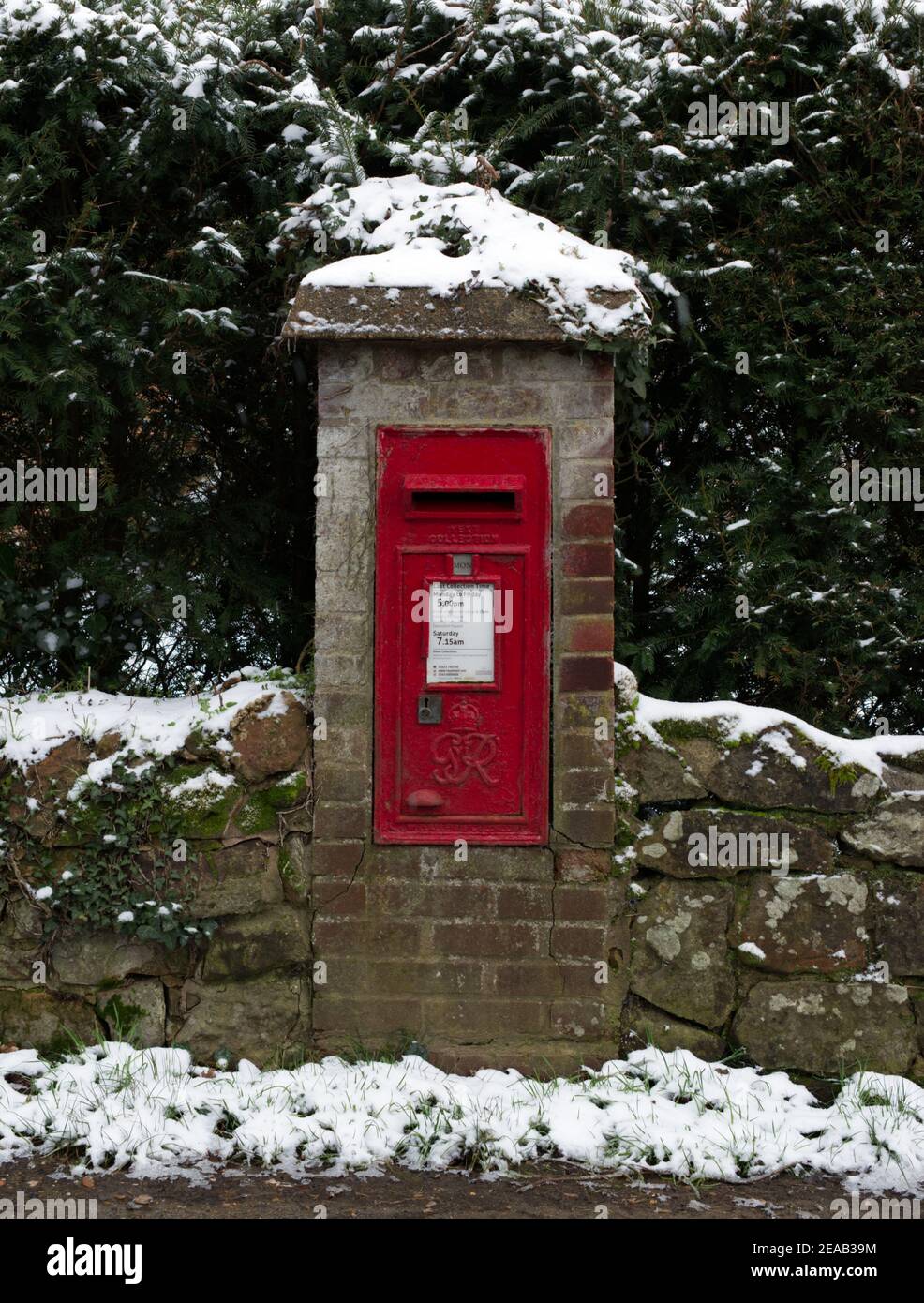 Une boîte à poste montée dans un mur dans un village avec de la neige. Pendant l'hiver. Banque D'Images