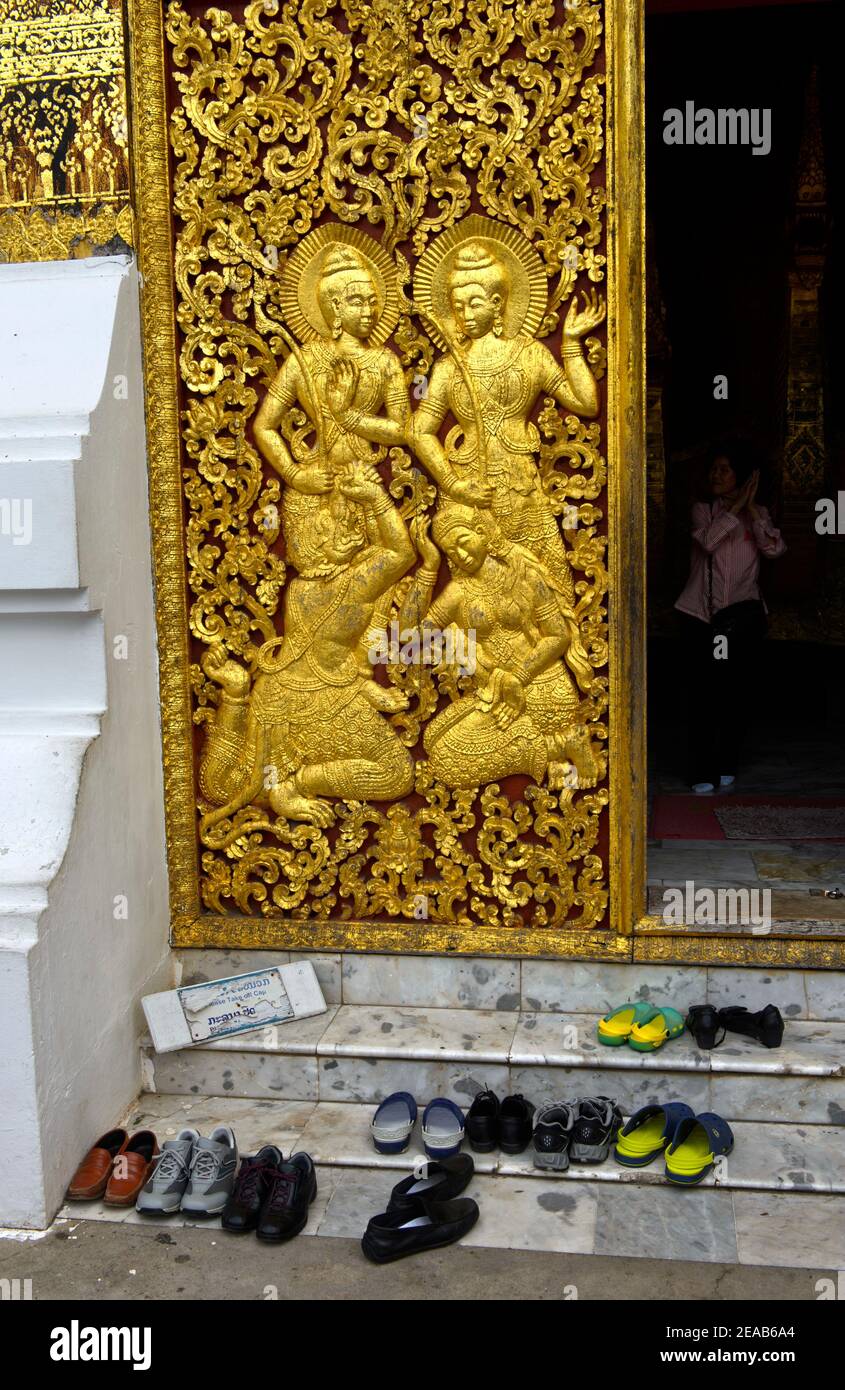 Chaussures de visiteurs devant la porte de la maison du wagon funéraire royal, temple Wat Xieng Thong, Luang Prabang, Laos Banque D'Images