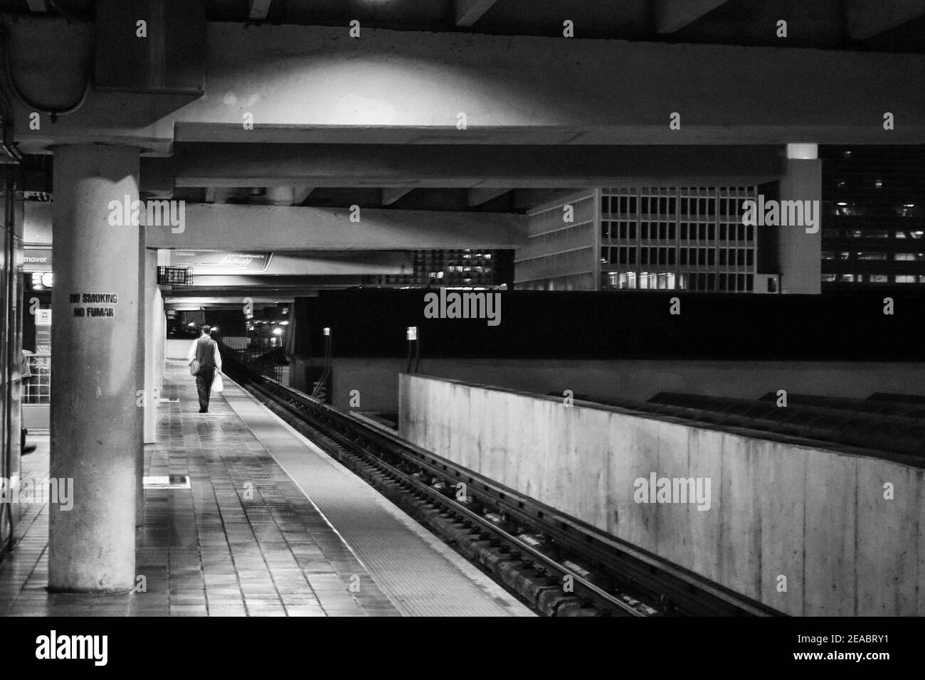 Un homme solitaire marche le long de la plateforme de Metrorail du Government Center tard dans la nuit dans le centre-ville de Miami, en Floride. Banque D'Images Un homme solitaire marche le long de la plateforme de Metrorail du Government Center tard dans la nuit dans le centre-ville de Miami, en Floride. Banque D'Images