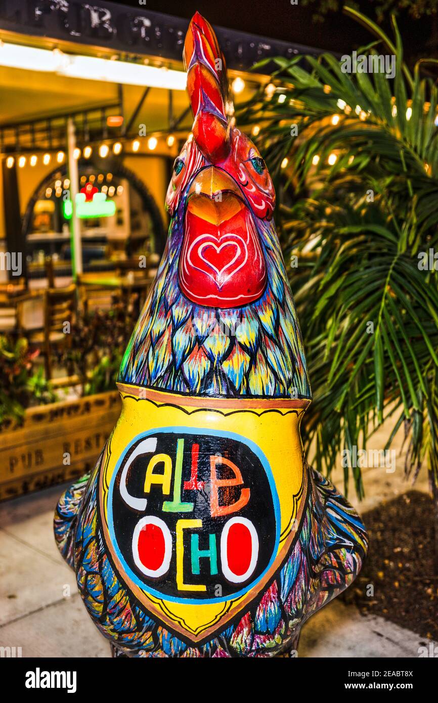 Une statue de coq colorée peinte avec des diamants multicolores et Calle Ocho se connecter devant un restaurant dans la petite Havane de Miami. Banque D'Images