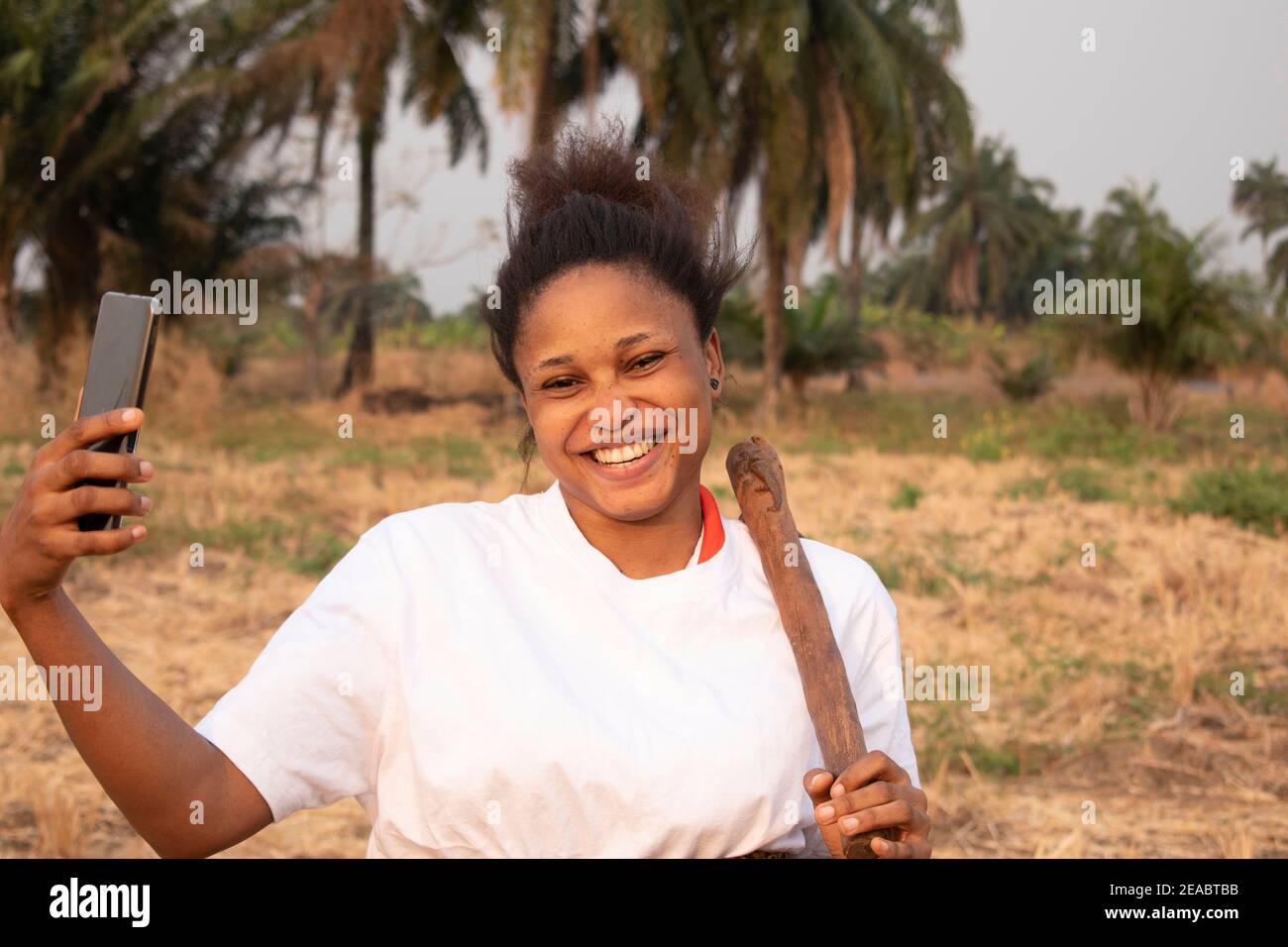 une femme africaine heureuse de ses terres agricoles Banque D'Images