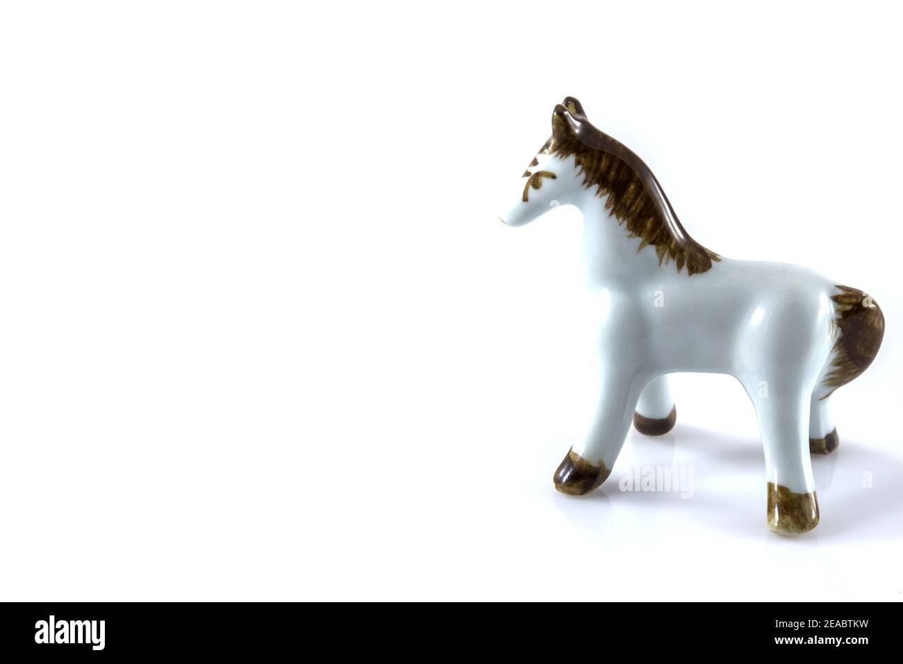 figurine blanche en céramique d'un cheval sur fond blanc Banque D'Images