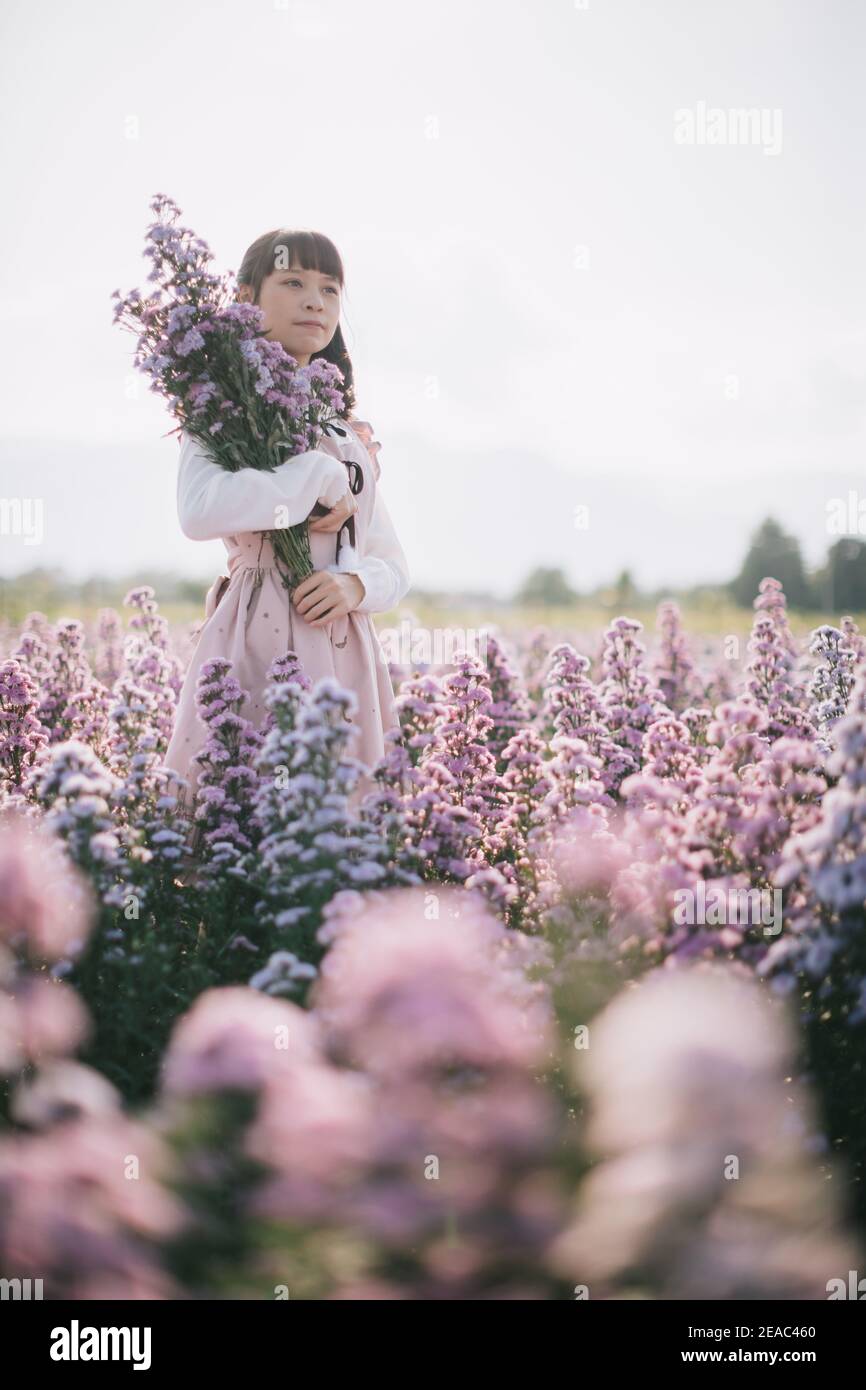 Portrait de fille asiatique avec fond de fleurs violettes Banque D'Images