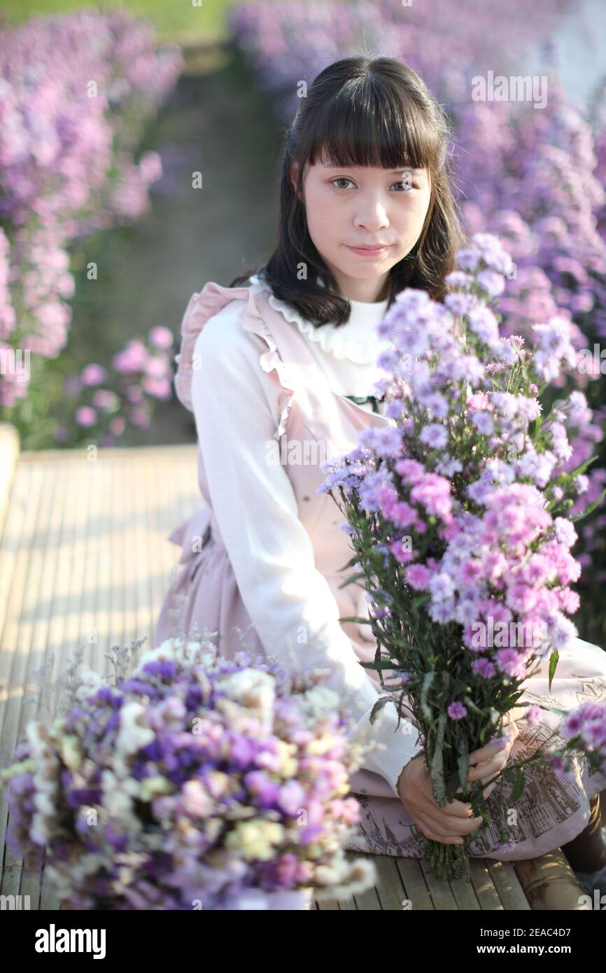 Portrait de fille asiatique avec fond de fleurs violettes Banque D'Images