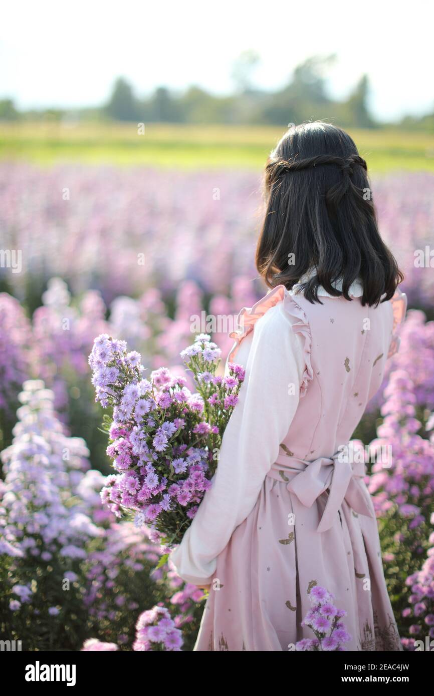Portrait de fille asiatique avec fond de fleurs violettes Banque D'Images