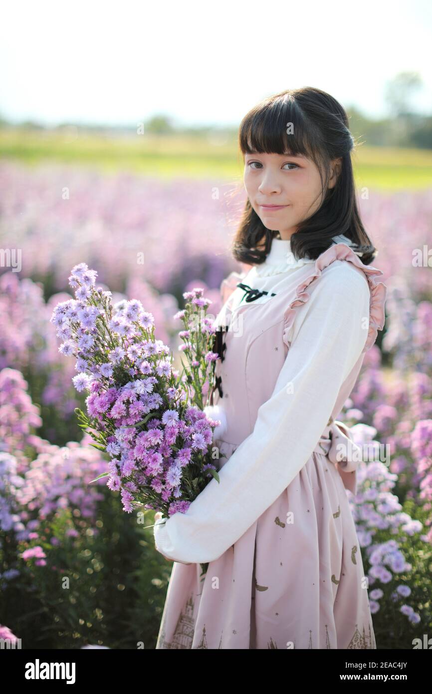 Portrait de fille asiatique avec fond de fleurs violettes Banque D'Images