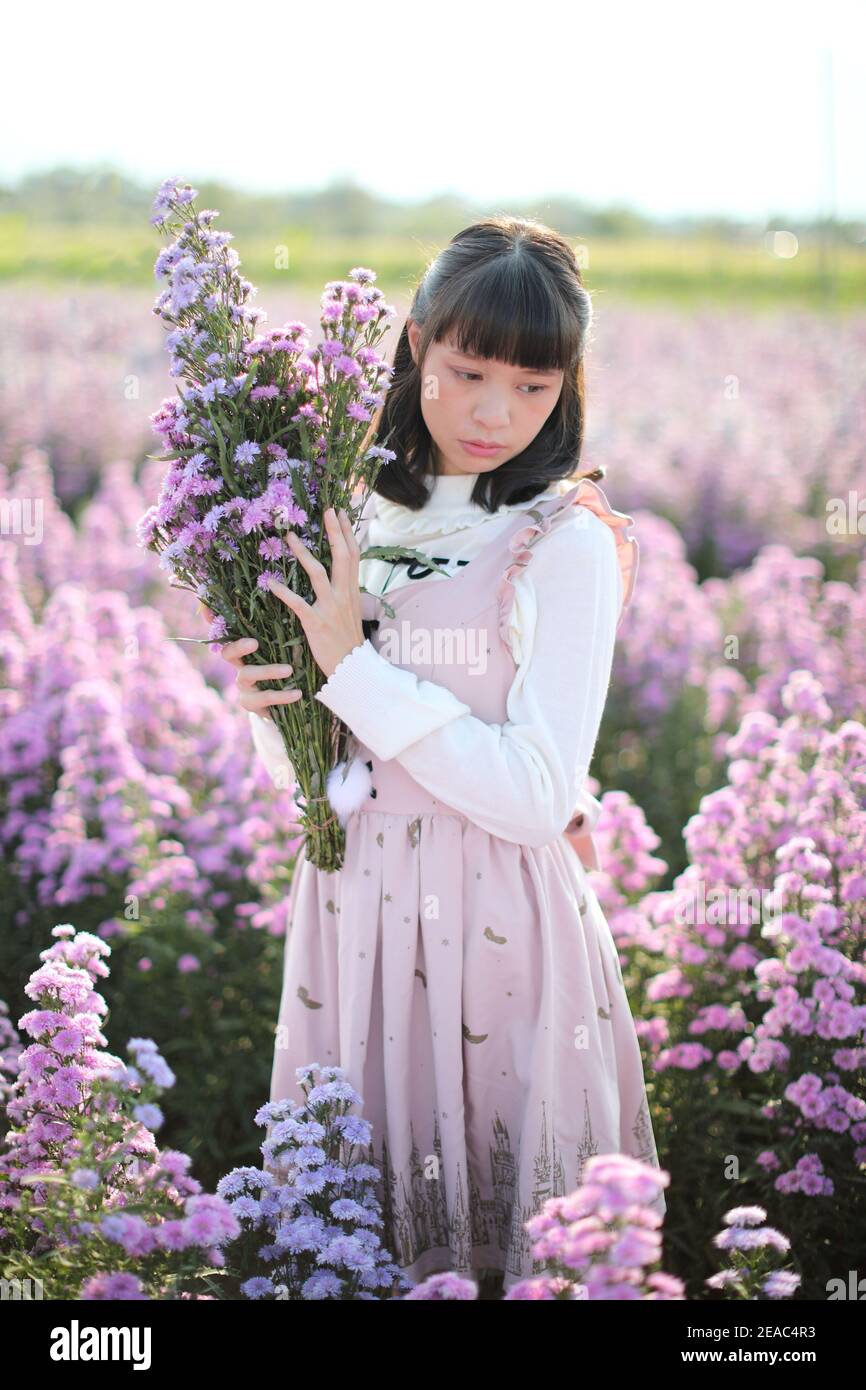 Portrait de fille asiatique avec fond de fleurs violettes Banque D'Images
