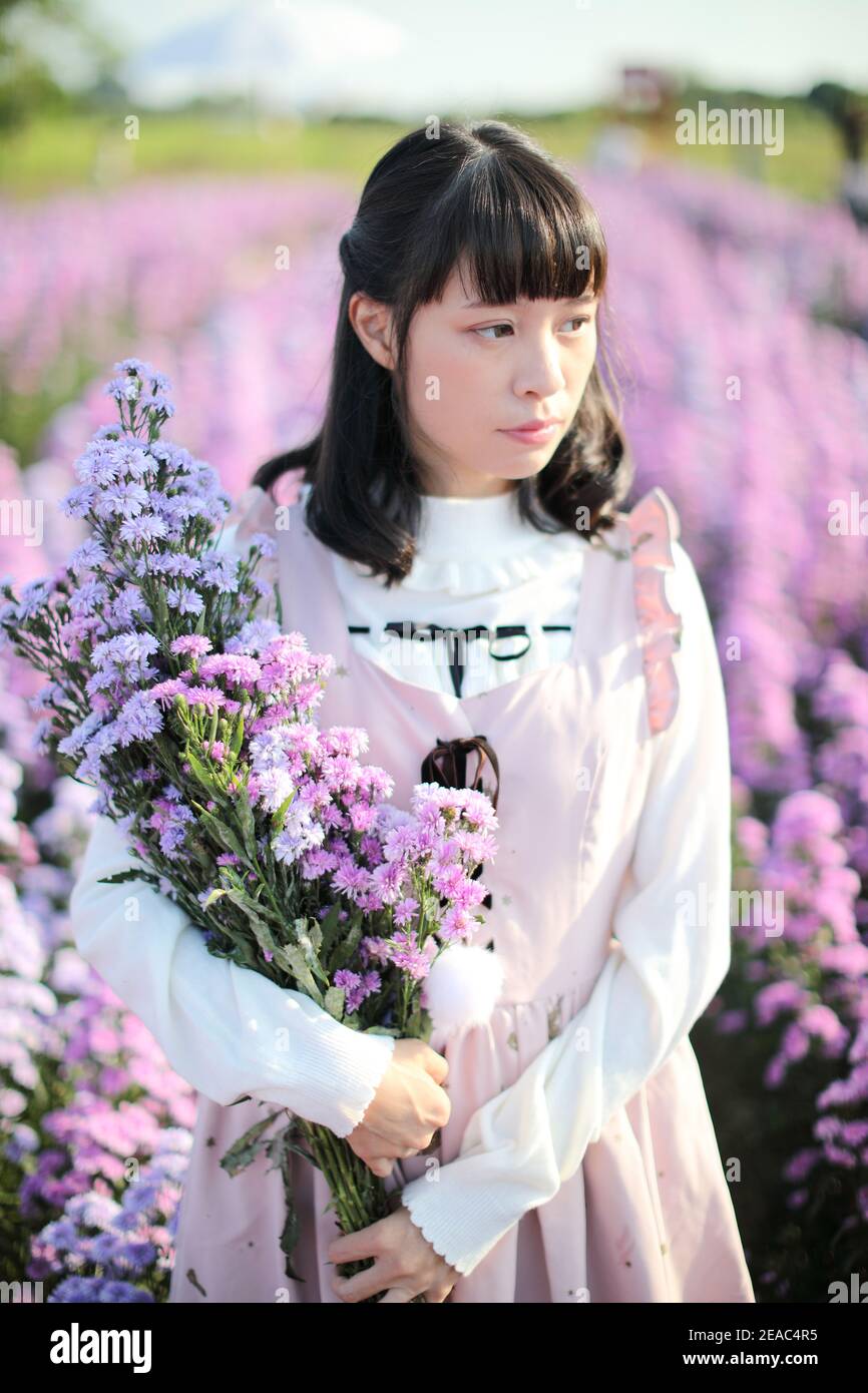 Portrait de fille asiatique avec fond de fleurs violettes Banque D'Images