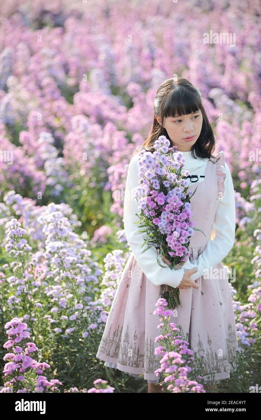 Portrait de fille asiatique avec fond de fleurs violettes Banque D'Images